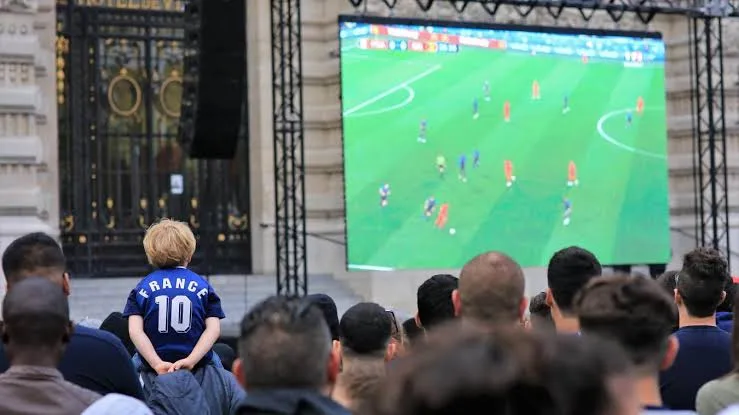 Public rassemblé devant un écran géant loué pour la retransmission d'un événement sportif
