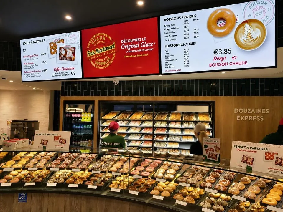 Écran LED portrait en vitrine d'un établissement à Rouen, affichant "Rouen, l'art de vivre normand"