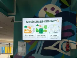 Écran d'information mural dans le hall d'un collège, affichant les éco-gestes à la cantine, dans la cour et en classe